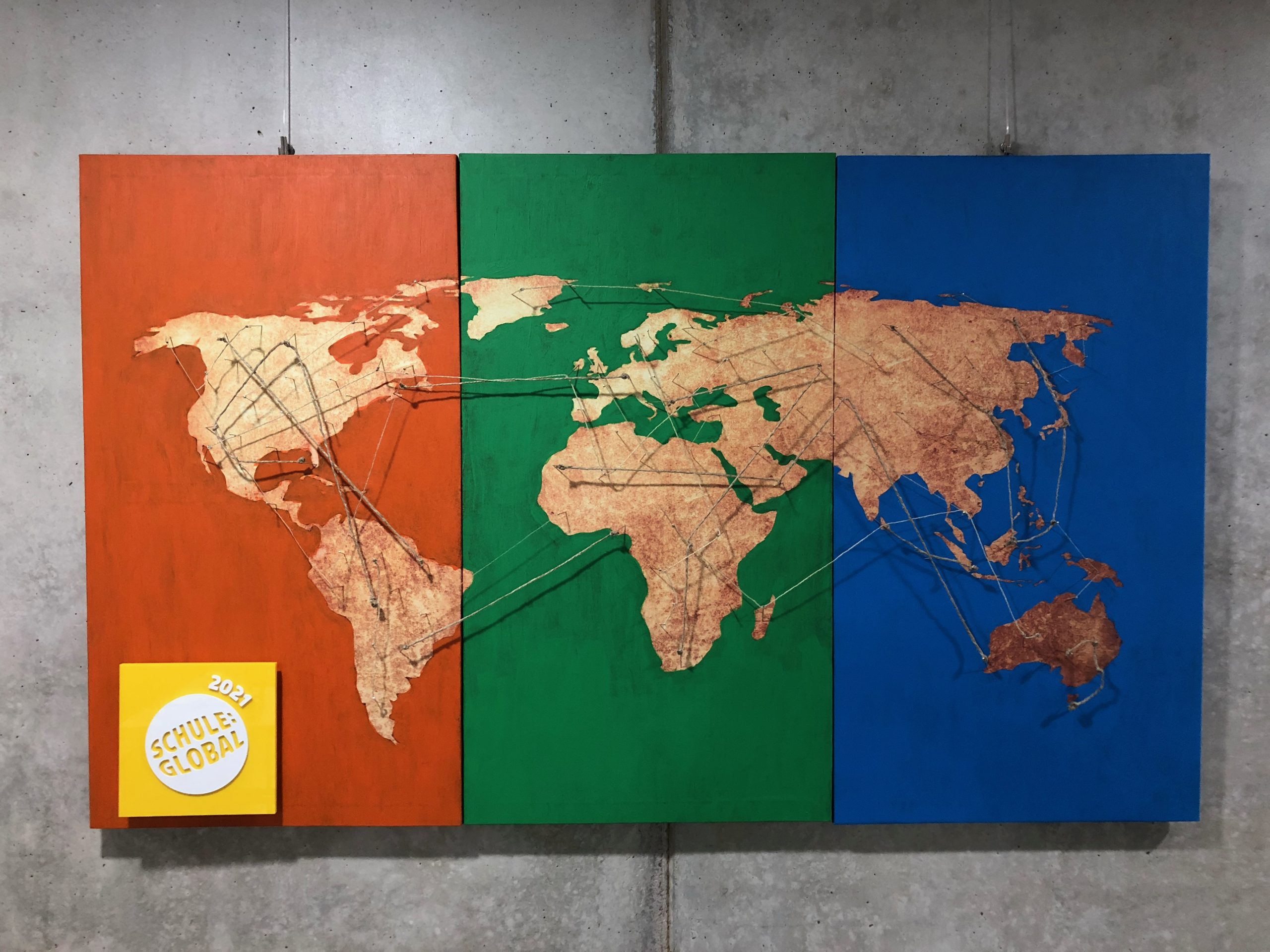 Eine im AK MKG International gestaltete Weltkarte mit dem gelben Siegel Schule:Global